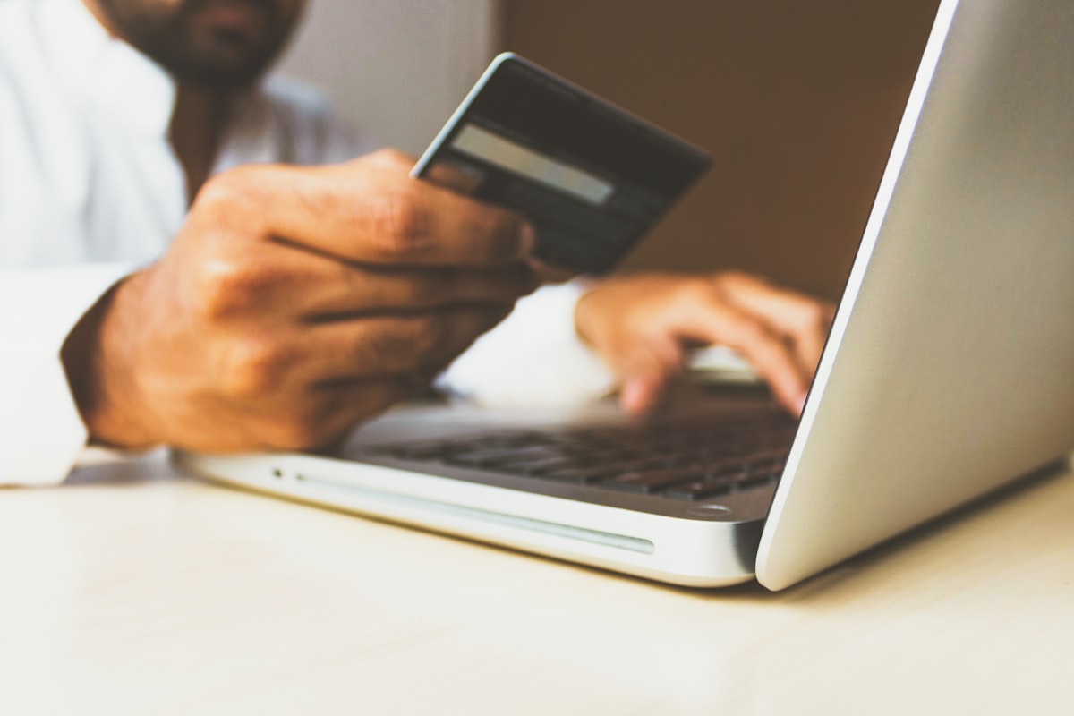 Person shopping online with credit card and laptop